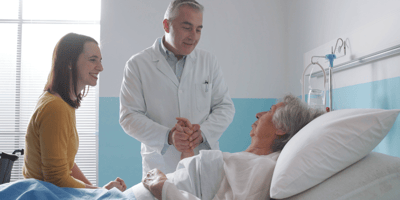 Médecin professionnel rencontrant une patiente âgée sur un lit d'hôpital