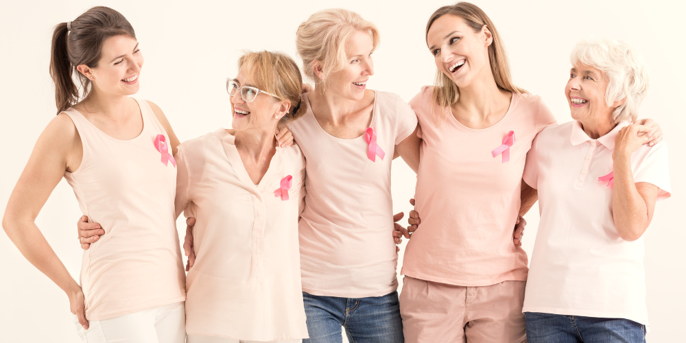 Femmes souriantes de cinq générations avec des rubans roses embrassant l'autre, concept de cancer du sein